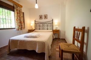 a bedroom with a bed and a chair and a window at Casa rural Molino Jaráiz Ideal Familias y Grupos 8 Pax Terraza sobre el Río Tus in Yeste