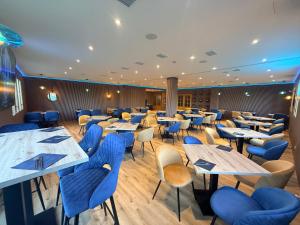 a dining room with tables and chairs and blue chairs at HOTEL Restaurante TurMo in Labuerda
