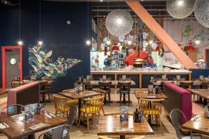a restaurant with wooden tables and chairs and a bar at The Heath Haven- Morden 4 Bedroom House Near Station High Street, Free Parking WiFi in Goodmayes