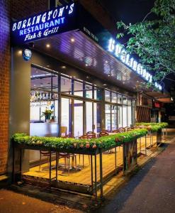 a restaurant with a table with plants in front of it at The Heath Haven- Morden 4 Bedroom House Near Station High Street, Free Parking WiFi in Goodmayes
