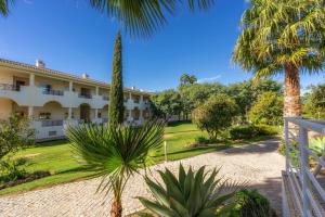 a resort with palm trees and a courtyard at Colina Verde Resort in Moncarapacho