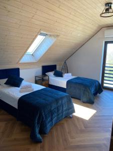two beds in a room with two windows at Białe Żagle Mazury in Węgorzewo