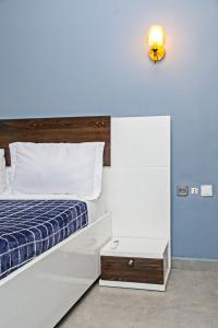 a bedroom with a bed and a light on the wall at Angel's hôtel in Douala