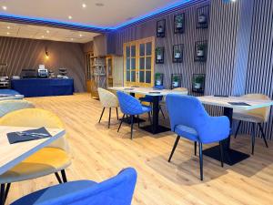 a restaurant with blue chairs and tables in a room at APARTAMENTOS Hotel TurMo in Labuerda