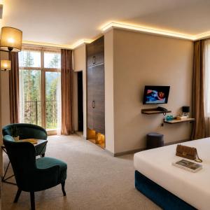 a hotel room with a bed and a chair at Вила АРБОРЕТУМ in Teteven