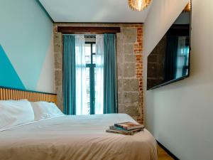 a bedroom with a bed with a mirror and a window at Hotel Terracota mx in Mexico City