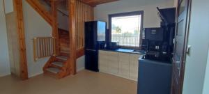 a kitchen with a staircase leading into a kitchen with a sink at Domki Malibu in Tupadła