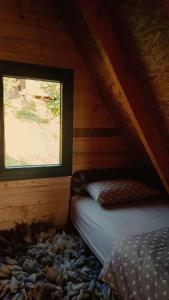 a bedroom with a bed and a window in a attic at Hasan's Place Temnjaci in Plav