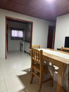a dining room with a table and a kitchen at Cabañas Adorable Tranquilidad in Cavalango