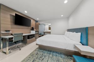 a bedroom with a bed and a desk and a tv at Hotel Miramar in San Clemente