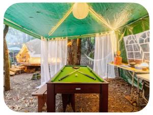 a ping pong table in a tent with a pool table at Glamping Boutique in Comillas