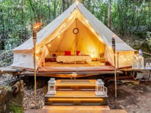 a large tent with a bed in the woods at Glamping Boutique in Comillas +12 photos