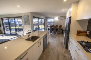 a large kitchen with white cabinets and a large window at Stay at 2A in Twizel