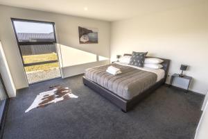 a bedroom with a bed and a large window at Stay at 2A in Twizel