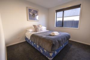 a small bedroom with a bed and a window at Stay at 2A in Twizel