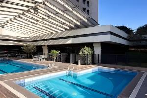 a swimming pool next to a building at Flat Moderno em Congonhas com sofá-cama 1113 in São Paulo