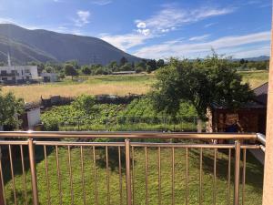 a balcony with a view of a field and mountains at Cozy 2 bedroom apartment in Sarajevo