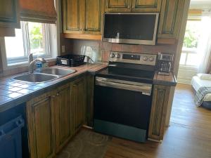 a kitchen with a stove and a sink and a microwave at Spacious Bright Home In Woodbridge in Vaughan