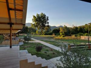 a building with a walkway and a park with trees at Glamping Lake Escape in Virpazar