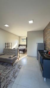 a large living room with a couch and a bed at Studios Carambeí in Carambeí