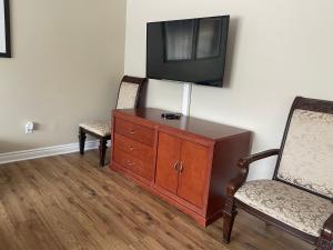 a room with two chairs and a television on a wall at Spacious Bright Home In Woodbridge in Vaughan