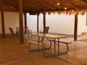 a group of picnic tables and chairs in a pavilion at Departamento ‘El Chulo’ en Palapa Ochoa in Loreto