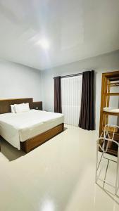 a bedroom with a bed and a window and a chair at Mama Homestay in Kuta Lombok