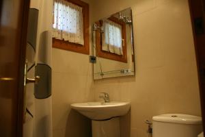 uma casa de banho com um lavatório, um WC e um espelho. em Apartamentos Cogulla em Benasque