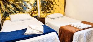 a room with two beds with towels on them at Concubinas del Inca in Cajamarca