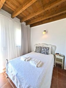 a bedroom with a white bed with a wooden ceiling at Olhão Barreta typical home ASM in Olhão