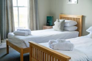 a hotel room with two beds with towels on them at The Sportsman in Amberley