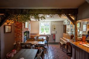 a restaurant with tables and chairs and a fireplace at The Sportsman in Amberley +37 photos