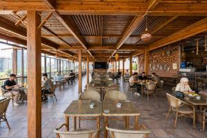 a restaurant with wooden tables and people sitting at tables at St George Hotel - The Zoo in Cairo