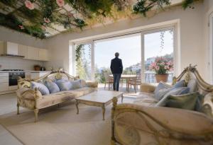 Ein Mann steht in einem Wohnzimmer mit einem großen Fenster in der Unterkunft Prima Stella in Positano