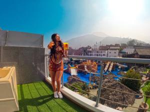 a woman standing on a balcony looking out at the city at Colpeña Chinchana in Chosica
