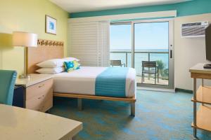 a bedroom with a bed with a view of the ocean at Waikiki Circle Hotel by Castle in Honolulu +105 photos
