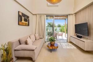 a living room with a couch and a tv at Villa Romas 3 by Villa Plus in Vasilikos