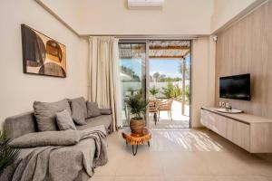 a living room with a couch and a tv at Villa Romas 2 by Villa Plus in Vasilikos