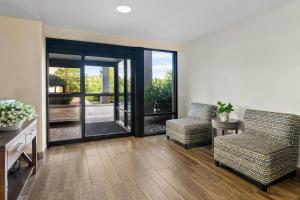 a living room with two chairs and a sliding glass door at Allentown Park Hotel by The Red Collection in Fogelsville +42 photos