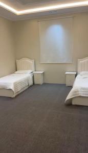 a room with two beds and a projection screen at شقق ورد in Al Barkah +1 photo