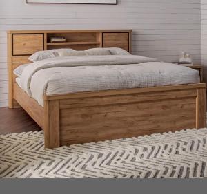 a wooden bed in a bedroom with a rug at شقق ورد in Al Barkah