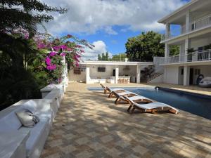 a row of benches next to a swimming pool at Casa Venus in El Gigante