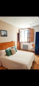 a bedroom with a large bed with green pillows at HOTEL PIORNEDO in Lugo
