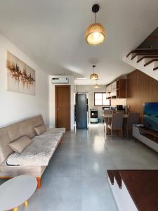 a large living room with a couch and a kitchen at Duplex Praia de Imbassaí in Mata de Sao Joao
