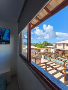 a window in a room with a view of a deck at Duplex Praia de Imbassaí in Mata de Sao Joao