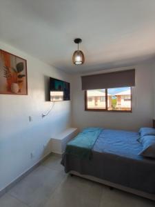 a bedroom with a blue bed and a window at Duplex Praia de Imbassaí in Mata de Sao Joao +27 photos