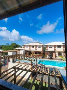 a view of the pool from the balcony of a resort at Duplex Praia de Imbassaí in Mata de Sao Joao