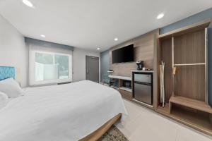 a bedroom with a large bed and a flat screen tv at Hotel Miramar in San Clemente