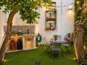 a garden with a table and a tree in it at Le case di Rebecca in Palermo
