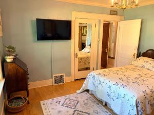 a bedroom with a bed and a flat screen tv at This Old Frat House Boutique Guest in Missoula
